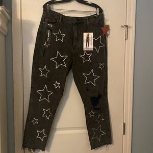 Black blue jeans with rips and rhinestone stars stonewash